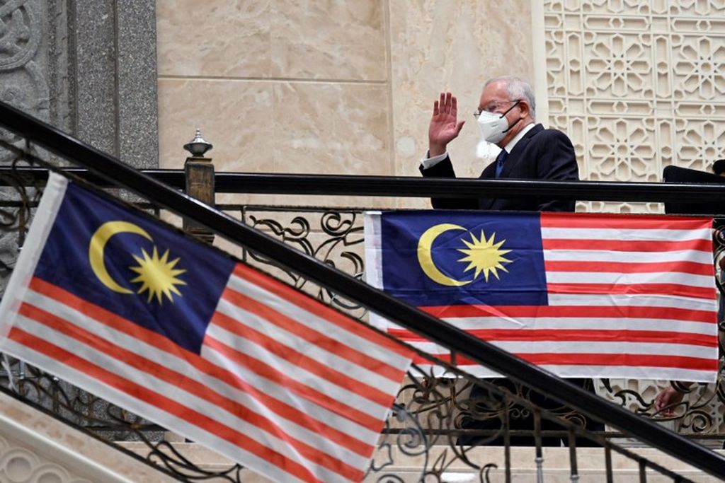 Dalam foto yang diambil pada 15 Agustus 2022 tampak mantan Perdana Menteri Malaysia, Najib Razak melambaikan tangan saat ia tidak di Gedung Pengadilan Federal Malaysia di Putrajaya. 