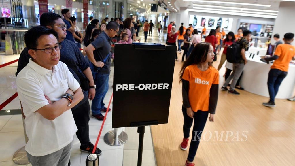 Calon pembeli menunggu giliran masuk ke dalam salah satu gerai ritel resmi Apple saat penjualan perdana telepon seluler iPhone XS, XS Max, dan XR untuk pasar Indonesia di Mal Central Park, Jakarta, Jumat (14/12/2018). 