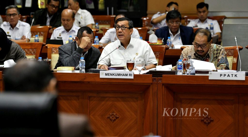 Menteri Hukum dan Hak Asasi Manusia Yasonna Laoly (tengah) dan Kepala Pusat Pelaporan dan Analisis Transaksi Keuangan (PPATK) Kiagus Ahmad Badaruddin (kanan) mengikuti rapat kerja dengan Komisi III DPR di Komplek Parlemen, Jakarta, Kamis (13/6/2019).