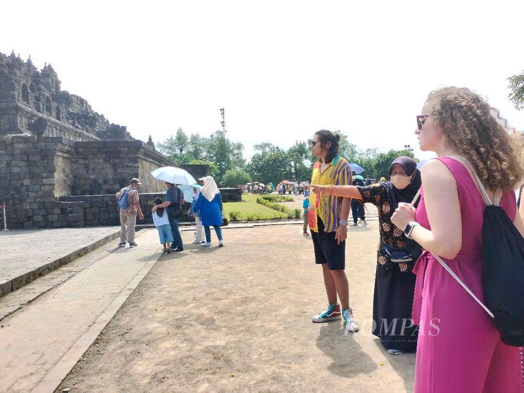 Rombongan wisatawan asal Spanyol mendengarkan penjelasan pemandu wisata perihal sejarah Candi Borobudur, Senin (4/7/2022), di Magelang, Jawa Tengah.