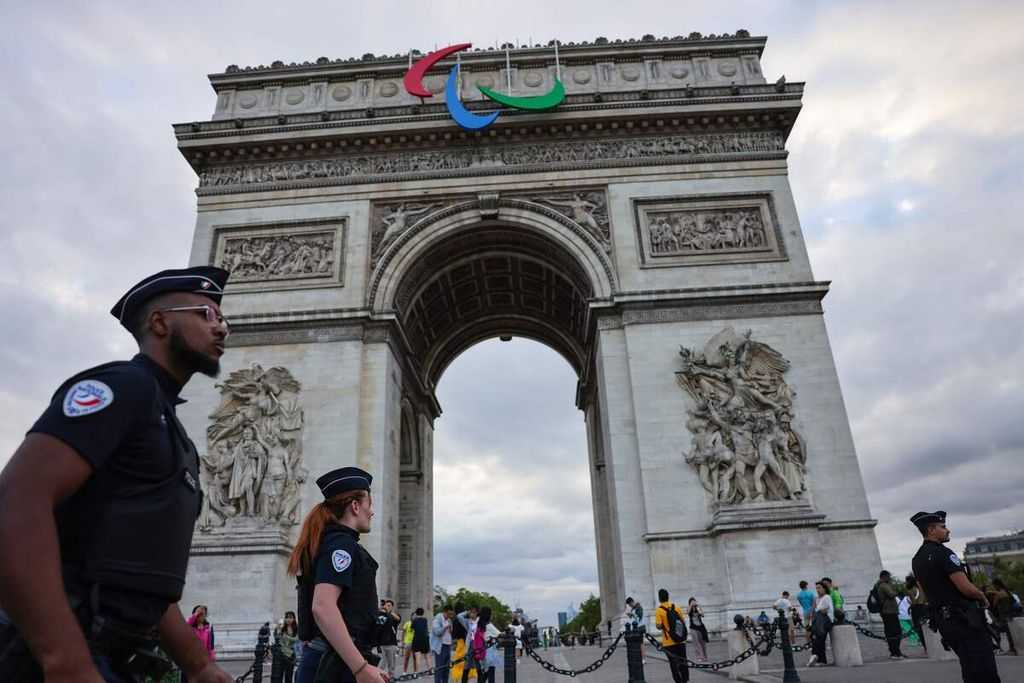 Polisi nasional Perancis berpatroli di sekitar monumen Arc de Triomphe  menjelang pembukaan Olimpade Paris 2024, Senin (22/7/2024). Sebanyak 25.000 polisi dan Gendarmerie ditugaskan untuk mengamankan Olimpiade dan Paralimpiade Paris 2024.