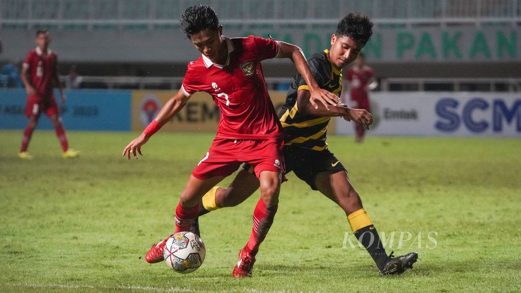 Indonesia U-17 midfielder Figo Dennis Saputrananto (left) fights for the ball with Malaysia U-17 team defender Muhammad Danish Darus (right) in the U-17 2023 Asian Cup Qualification match at Pakansari Stadium, Bogor, West Java, on Sunday (9/10/2022).