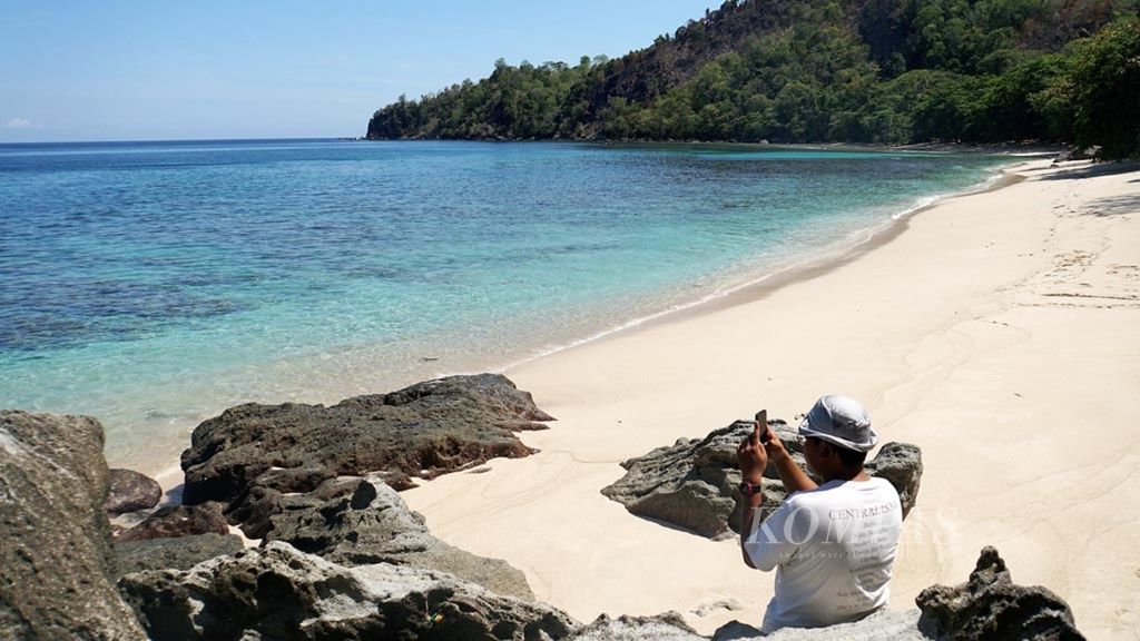 Wisatawan mengambil foto di Pantai Pulisan, Likupang Timur, Minahasa Utara, Sulawesi Utara, Sabtu (9/11/2019). Pantai ini merupakan destinasi wisata utama di wilayah yang bakal dijadikan Kawasan Ekonomi Khusus Likupang karena airnya yang jernih dan pasir putihnya.