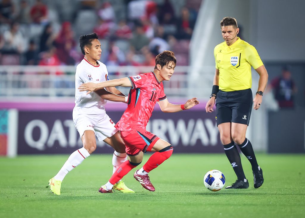 Kapten Indonesia, Rizky Ridho (kiri), mencoba menahan laju pemain Korea Selatan, Kang Seong-jin, pada pertandingan perempat final Piala Asia U-23 2024 di Stadion Abdullah bin Khalifa, Doha, Qatar, Jumat (26/4/2024).
