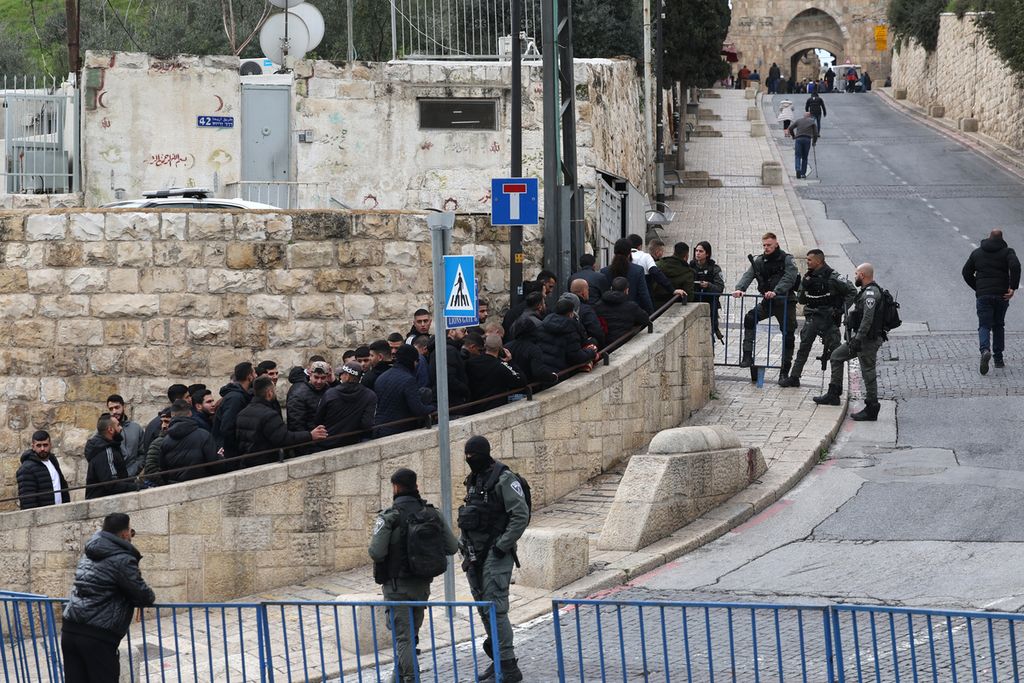 Anggota pasukan keamanan Israel berjaga ketika jemaah Muslim menunggu di pos pemeriksaan dekat Gerbang Singa untuk memasuki kompleks Masjid Al-Aqsa sebelum shalat Jumat, di Jerusalem, 16 Februari 2024.