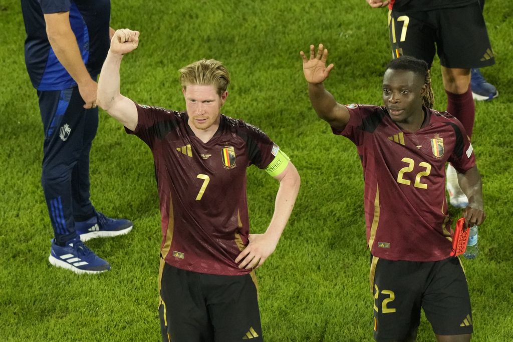 Kapten Belgia, Kevin De Bruyne (kiri), dan Jeremy Doku merayakan kemenangan atas Romania pada laga Grup E Piala Eropa 2024 di Cologne, pada 22 Juni 2024. Persaingan di Grup E sangat ketat karena hingga laga kedua semua tim meraih tiga poin.