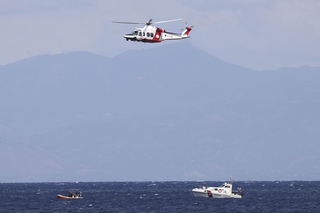 Sebuah helikopter dan tiga kapal pencari dikerahkan penjaga pantai Italia di Porticello, Italia, Senin (19/8/2024), untuk mencari enam penumpang kapal Bayesian yang karam dihantam badai pada Senin dini hari waktu setempat.