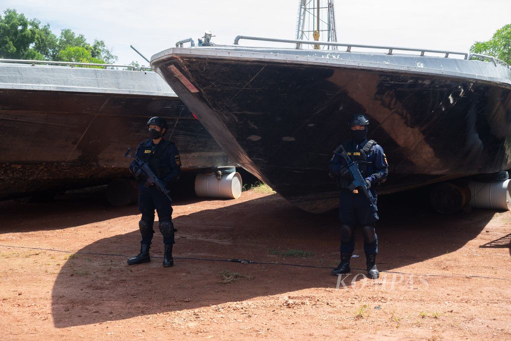 Petugas Direktorat Jenderal Bea dan Cukai Kementerian Keuangan menjaga sebuah <i>speedboat </i>yang menjadi barang bukti kasus penyelundupan rokok dan pencucian uang di Batam, Kepulauan Riau, Jumat (23/9/2022).