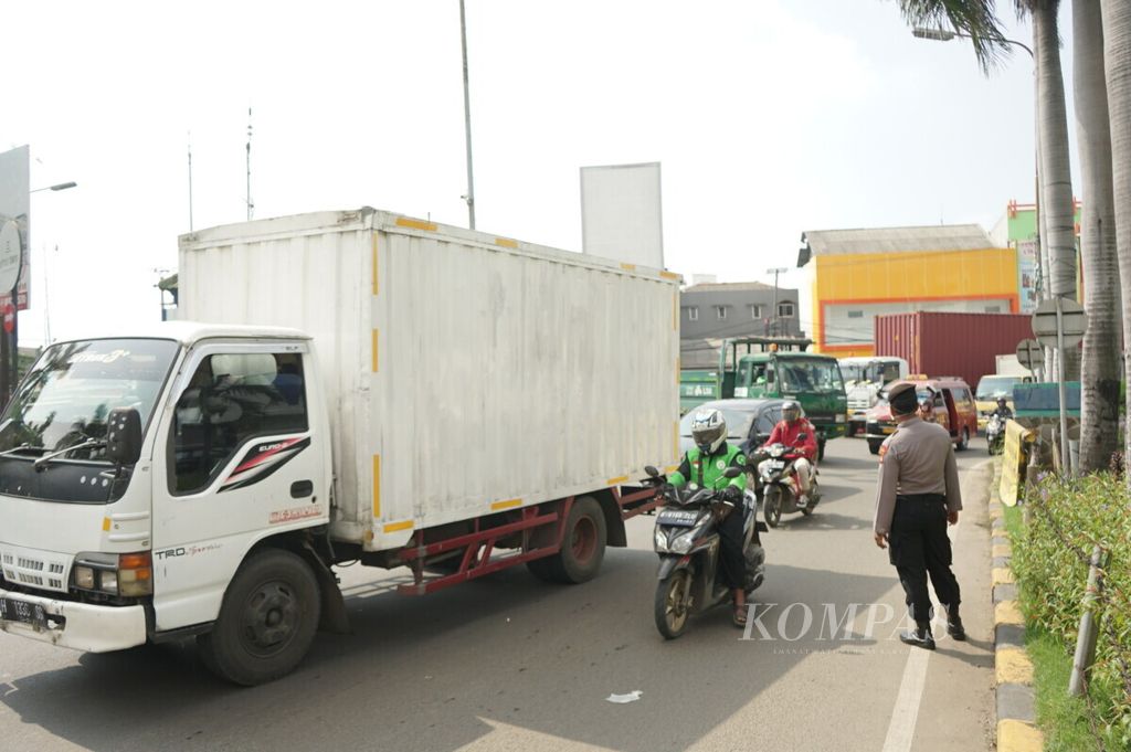 Kondisi lalu lintas masuk Kawasan Industri Jababeka, Bekasi, Jawa Barat, pada hari pertama pemberlakuan pembatasan sosial berskala besar, seperti terlihat pada Rabu (15/4/2020) pagi.