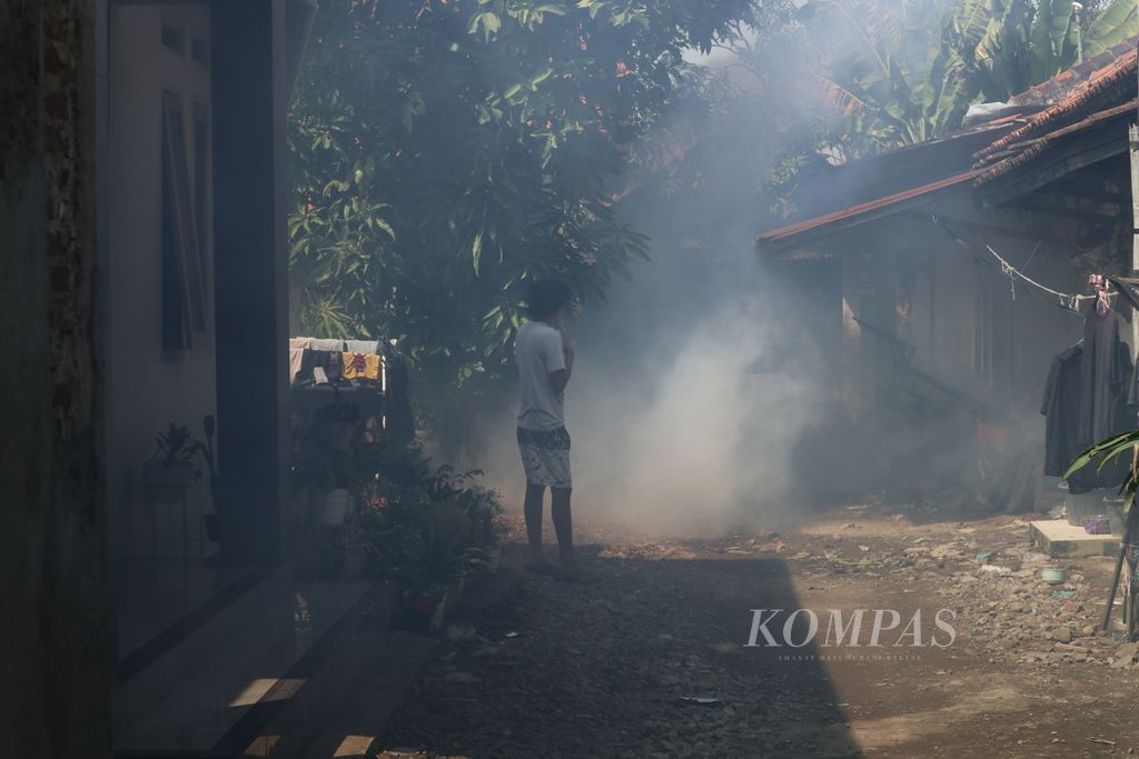 Seorang warga menyaksikan pengasapan atau <i>fogging </i>di Desa Pangkalan, Kecamatan Plered, Kabupaten Cirebon, Jawa Barat, Kamis (23/6/2022). Pengasapan tersebut untuk mengantisipasi penyebaran penyakit demam berdarah dengue.