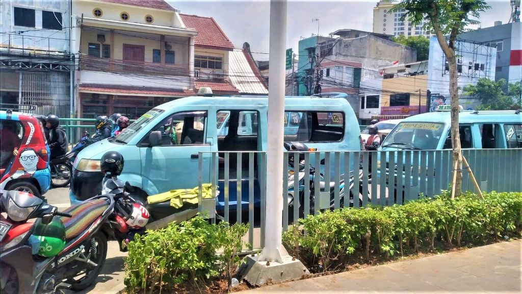 Sejumlah sepeda motor ojek daring dan angkot parkir di badan jalan di sekitaran Stasiun Jakarta Kota pada Kamis (6/10/2022). 