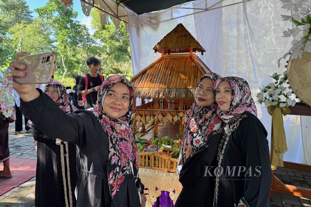 Visitors take photos with the backdrop of the Topat Agung at the Hikayat Lebaran Topat Mentaram event in Makam Bintaro, Ampenan District, Mataram City, West Nusa Tenggara, on Wednesday (April 17, 2024).