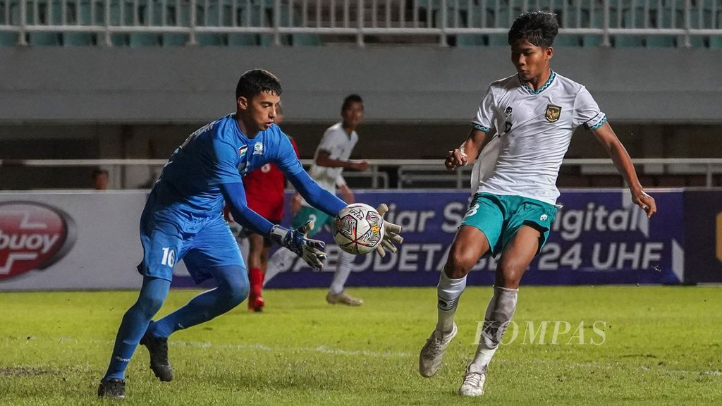 Kiper Palestina U-17, Mohammed Abushaqra (kiri), menangkap bola di bawah ancaman striker tim Indonesia U-17, Arkhan Kaka Putra (kanan), dalam laga Kualifikasi Piala Asia U-17 2023 di Stadion Pakansari, Bogor, Jawa Barat, Jumat (7/10/2022). 