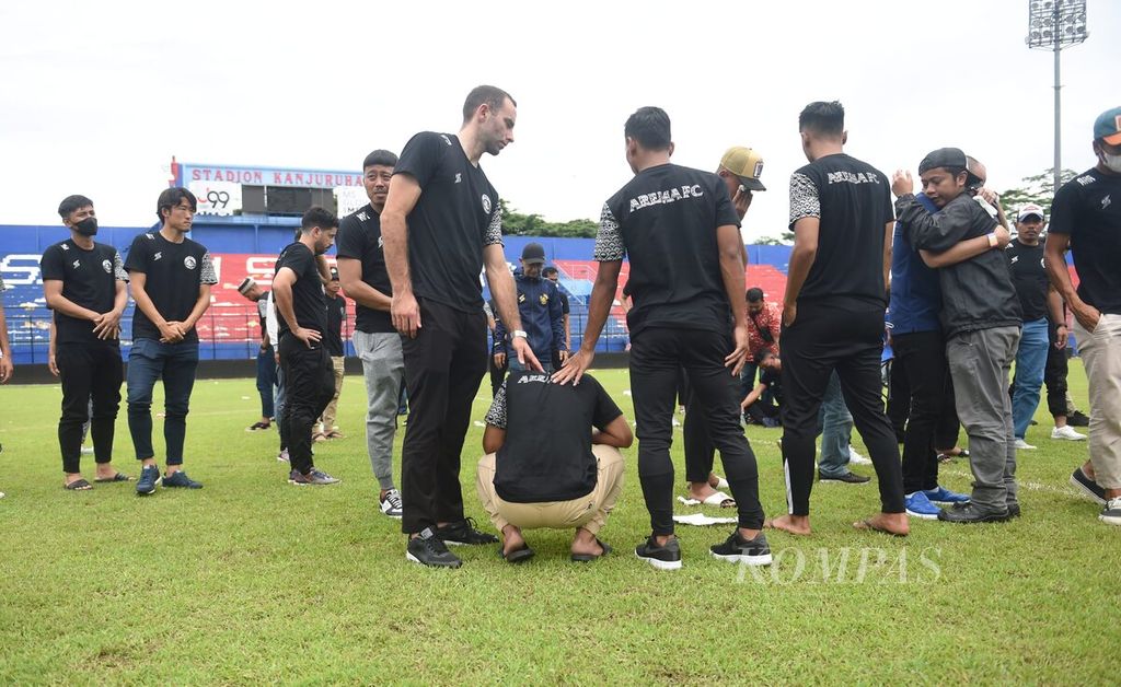 Pemain dan ofisial Arema FC berada di tengah lapangan di Stadion Kanjuruhan untuk memberikan penghormatan bagi korban yang meninggal saat kerusuhan, Kabupaten Malang, Jawa Timur, Senin (3/10/2022).