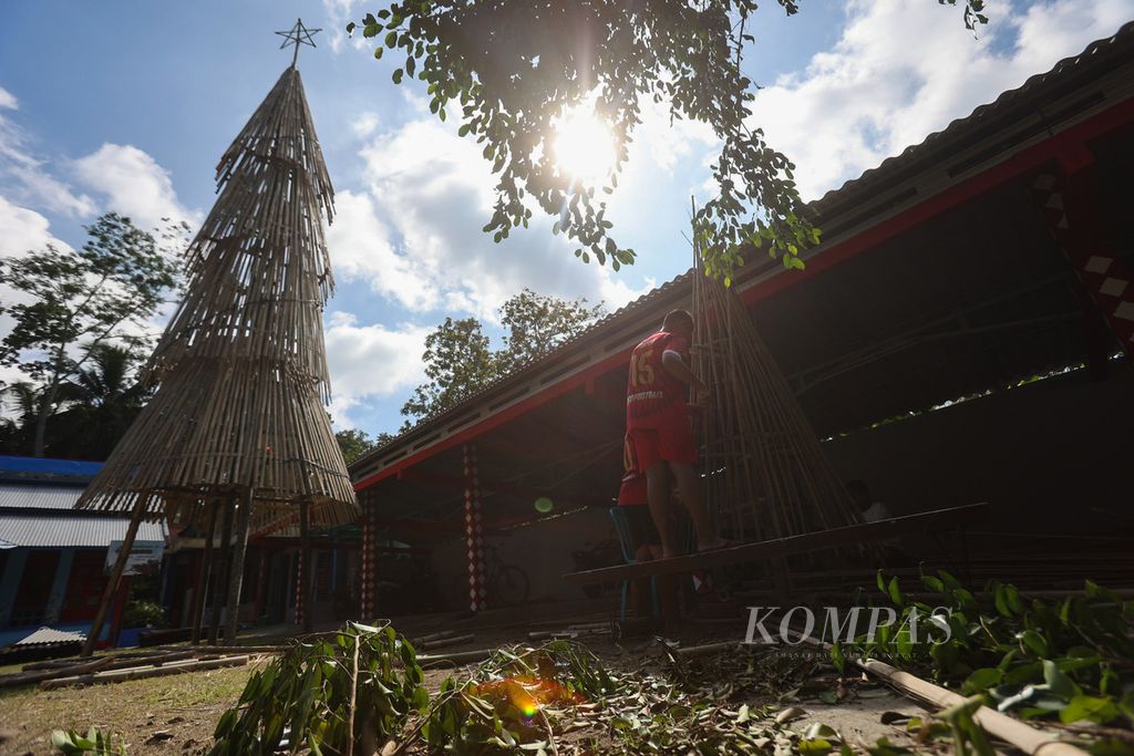 Warga menyelesaikan pembuatan pohon Natal dari bambu di halaman Kapel Stepanus Bunder, Desa Bandungan, Jatinom, Klaten, Jawa Tengah, Rabu (21/12/2022). Instalasi setinggi 12 meter yang dibuat dari 80 batang bambu jenis apus tersebut dikerjakan dalam waktu sekitar lima hari untuk menyambut hari raya Natal.