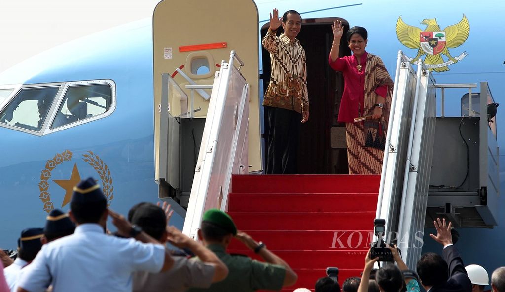Presiden Joko Widodo didampingi Ny Iriana Joko Widodo melambaikan tangan sebelum memasuki pesawat kepresidenan untuk kunjungan kerja perdana ke luar negeri, di Bandara Halim Perdanakusuma, Jakarta, Sabtu (8/11/2014). Presiden Jokowi akan menghadiri tiga acara di tiga negara, yakni pertemuan KTT APEC di Beijing (Tiongkok), KTT ASEAN di Naypyidaw (Myanmar), dan pertemuan G-20 di Brisbane (Australia).