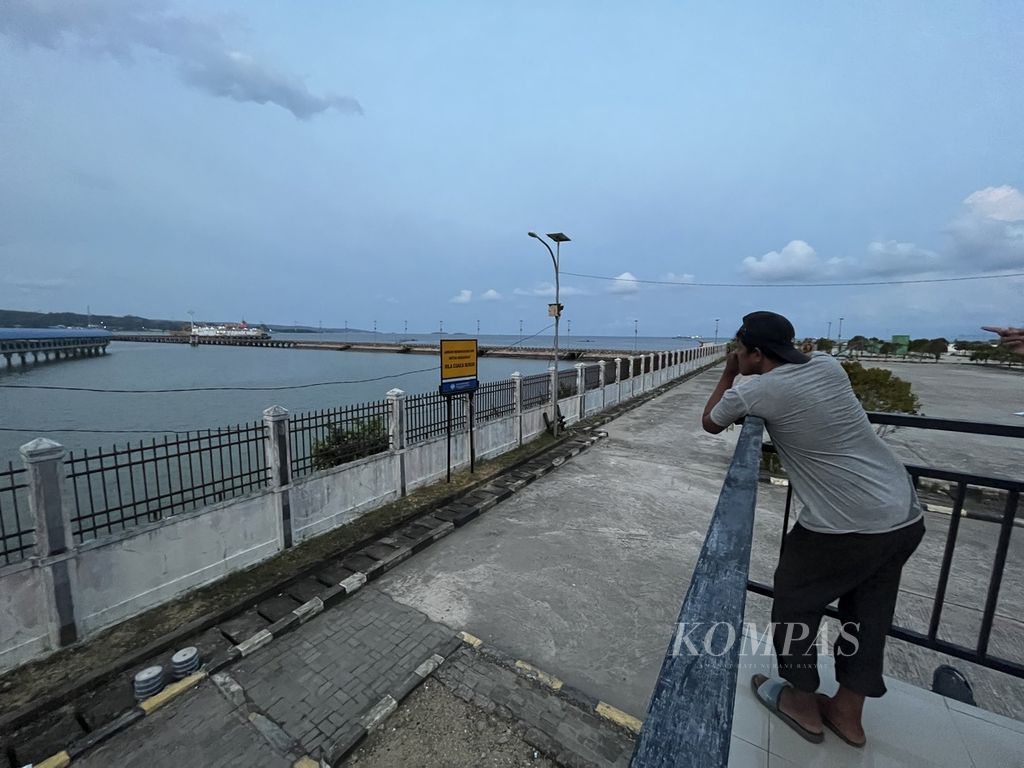Bobby (39), kuli angkut di Pelabuhan Bungkutoko, Kendari, Sulawesi Tenggara, menanti panggilan untuk mengangkut barang, Selasa (7/3/2023). 