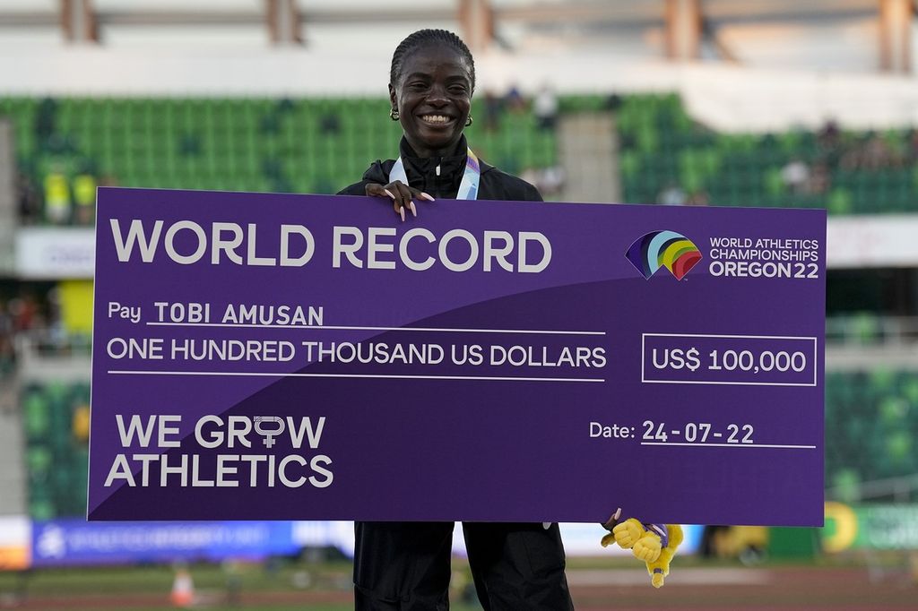 Pelari Nigeria, Tobi Amusan, memamerkan hadiah uang 100.000 dollar AS setelah memecahkan rekor dunia pada nomor 100 meter lari gawang putri Kejuaraan Dunia Atletik di Hayward Field, Oregon, Senin (25/7/2022) pagi WIB. Amusan mencatat rekor dunia pada nomor itu dengan waktu 12,06 detik.