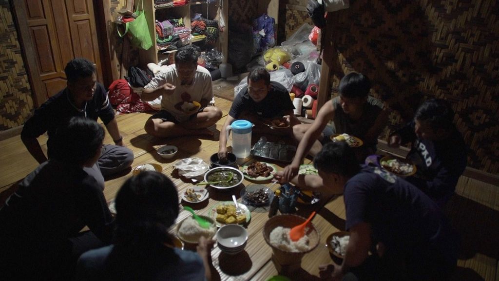  Wisatawan yang bermalam di rumah Kang Sarpin, warga Baduy Luar, tengah menikmati santap malam, Jumat (28/10/2022). Para tamu membawa bahan pangan untuk dimasak oleh tuan rumah dan dinikmati bersama.