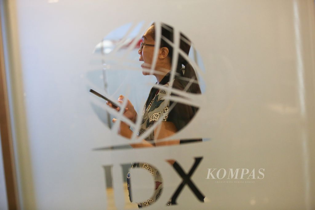 Employees walk past the Indonesia Stock Exchange logo in Jakarta on Tuesday (16/4/2024). The Composite Stock Price Index (IHSG) at the opening of trading this morning after the long Eid al-Fitr holiday was in the red zone.