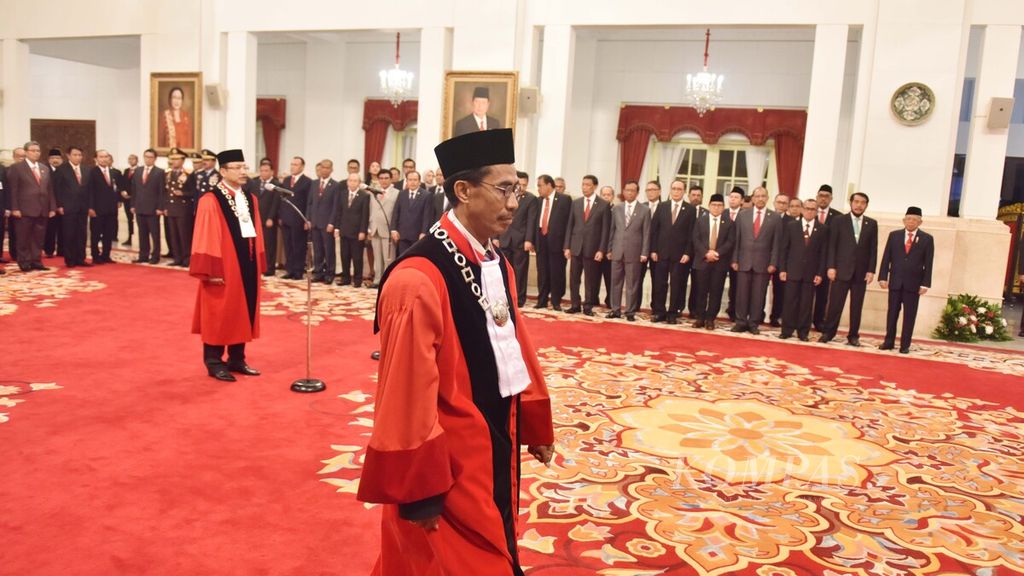Hakim Mahkamah Konstitusi (MK) Daniel Yusmic Pancastaki Foekh (depan) dan Suhartoyo (belakang) bersiap untuk menandatangani berita acara pengucapan sumpah jabatan hakim Mahkamah Konstitusi (MK) periode 2020-2025 di hadapan Presiden Joko Widodo di Istana Negara, Jakarta, Selasa (7/1/2019).