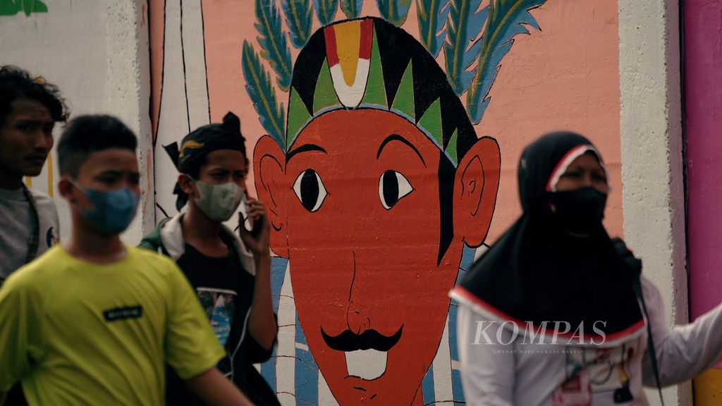 Warga melintasi mural menyambut HUT Ke-495 DKI Jakarta di Palmeriam, Matraman, Jakarta Timur, Minggu (19/6/2022). HUT Ke-495 DKI Jakarta tahun ini bertema Jakarta Hajatan. Pemerintah Provinsi DKI Jakarta menyambut hari jadi ke-495 dengan menggelar sejumlah acara sebulan penuh mulai 24 Mei sampai 25 Juni 2022. 