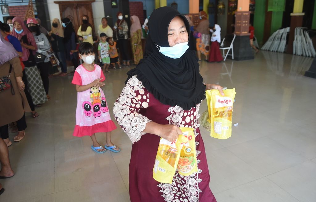 Warga membawa minyak goreng saat operasi pasar minyak goreng di Kantor Kecamatan Waru, Kabupaten Sidoarjo, Jawa Timur, Senin (24/1/2022). Harga minyak dijual Rp 14.000 per liter. Untuk satu KTP, warga berhak membeli 2 liter minyak goreng. 