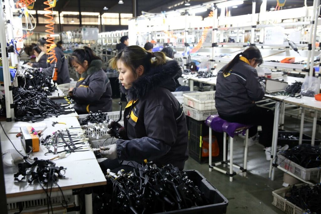 Dalam foto yang dirilis pada 28 November 2020 ini tampak sejumlah pekerja tengah bekerja di pabrik suku cadang sepeda motor di Huaibei, Anhui, China.