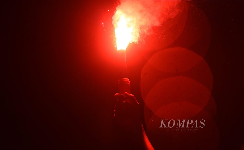 Supporters light flares while celebrating a goal while watching the match between Indonesia and Iraq in the fight for third place in the U-23 Asian Cup at Sidoarjo Square, Thursday (2/5/2024).
