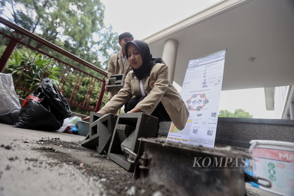 Mahasiswa Universitas Gadjah Mada (UGM) menyiapkan bahan untuk membuat batako enviroblock hasil inovasi mereka di kampus UGM, Kabupaten Sleman, Daerah Istimewa Yogyakarta, Senin (8/7/2024).