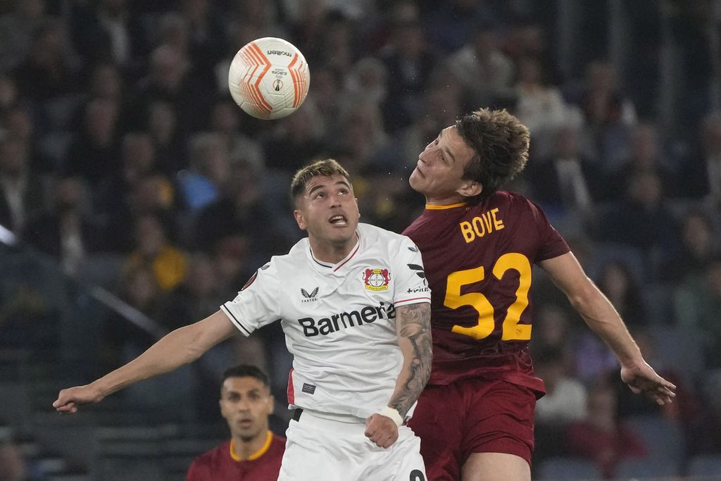 Gelandang AS Roma, Edoardo Bove (kanan), melompat berebut bola dengan pemain Bayer Leverkusen, Exequiel Palacios, dalam pertandingan laga<i></i>pertama semifinal Liga Europa antara AS Roma dan Bayer Leverkusen di Stadion Olimpico, Roma, Jumat (12/5/2023) dini hari. AS Roma menang 1-0 atas Bayer Leverkusen.