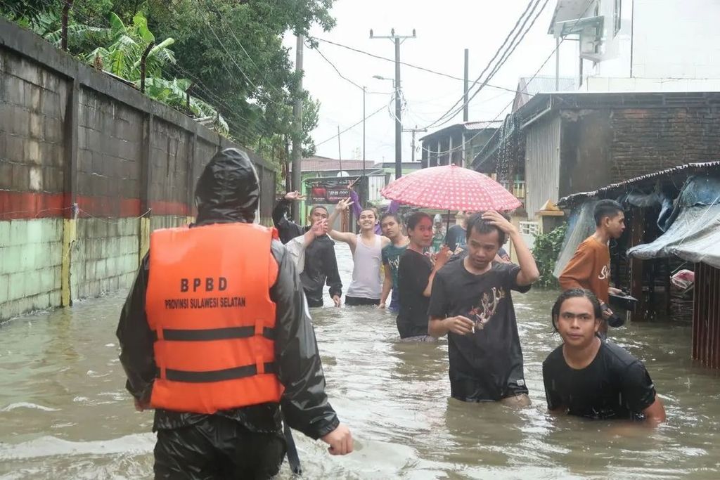 Warga yang terjebak banjir berusaha keluar dari permukiman di sejumlah wilayah di Makassar, Senin (13/2/2023). Perahu karet disiagakan untuk mengevakuasi warga.