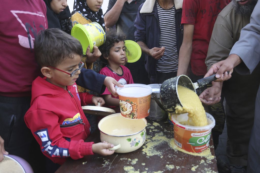 Warga Palestina antre untuk mendapatkan makanan selama pengeboman Israel yang sedang berlangsung di Jalur Gaza di Rafah, Senin (13/11/2023).