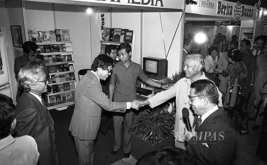 Presiden Soeharto disertai Ibu Tien mengunjungi stand Kompas Gramedia di Hall C PRJ Kemayoran disambut oleh PU Kompas Jakob Oetama, (9/2/1985). Pameran diselenggarakan dalam rangka Hari Pers Nasional 1985.