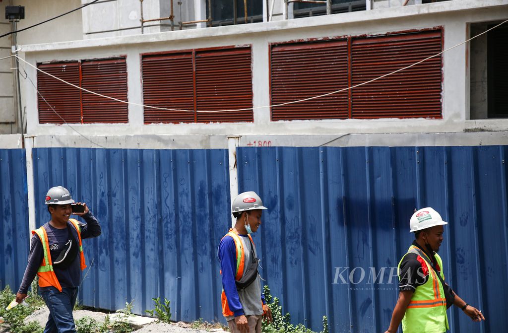 Pekerja keluar dari proyek properti di kawasan Kebon Melati, Tanah Abang, Jakarta Pusat, saat jam istirahat, Selasa (28/9/2021). 