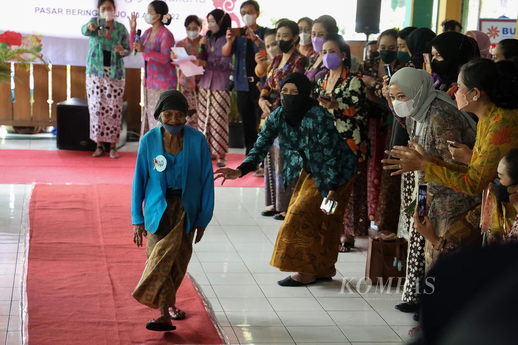 Buruh gendong bernama Pujiharjo (80) tampil dalam kegiatan peragaan busana dengan pakaian kebaya di Pasar Beringharjo, Yogyakarta, Rabu (20/4/2022). Kegiatan yang diikuti 41 perempuan buruh gendong tersebut digelar oleh komunitas Perempuan Berkebaya Yogyakarta untuk menyambut Hari Kartini.