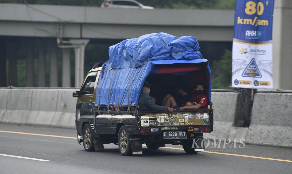 Warga yang mudik menggunakan mobil bak terbuka yang dilengkapi terpal sebagai penutup melintas di Km 47 Jalan Tol Jakarta-Cikampek di Karawang, Jawa Barat, Kamis (29/4/2022). 