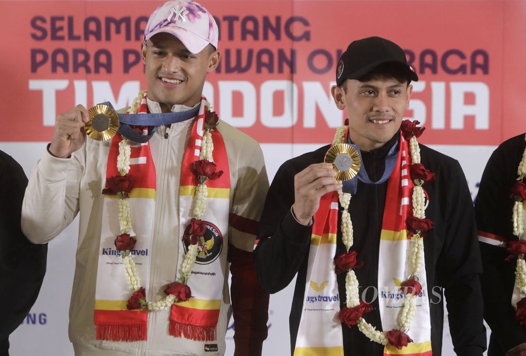 Atlet panjat tebing peraih medali emas pertama bagi Indonesia di Olimpiade Paris 2024, Veddriq Leonardo (kanan), yang bertanding di nomor <i>speed </i>putra, bersama lifter Rizki Juniansyah, yang juga meraih medali emas, di Gedung VIP Terminal 3 Bandara Soekarno-Hatta, Tangerang, Banten, Selasa (13/8/2024). 