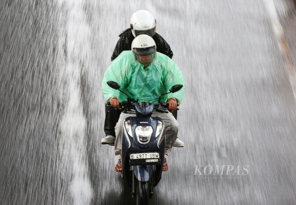 Illustration. Motorcyclists riding on Ciledug Raya Street during a rainy day in the Cipulir area, Kebayoran Lama, South Jakarta on Saturday (11/5/2024).