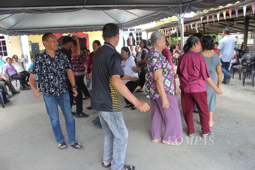 Masyarakat Dayak Bidayuh beragama Katolik dari Entikong, Kalimantan Barat, menari bersama masyarakat Dayak Bidayuh beragama Katolik di Kampung Entubuh, Sarawak, Malaysia, Minggu (17/12/2023).