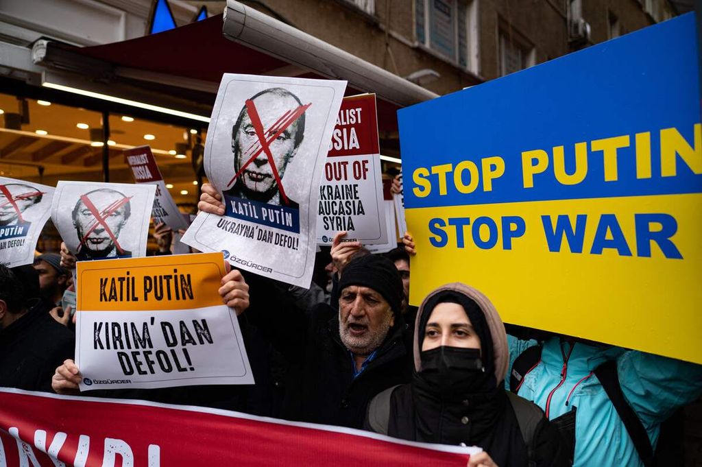 Para pengunjuk rasa memegang poster untuk menentang serangan militer Rusia di Ukraina dalam demonstrasi di depan Kedutaan Besar Rusia di Istanbul, Turki, 24 Februari 2022. 