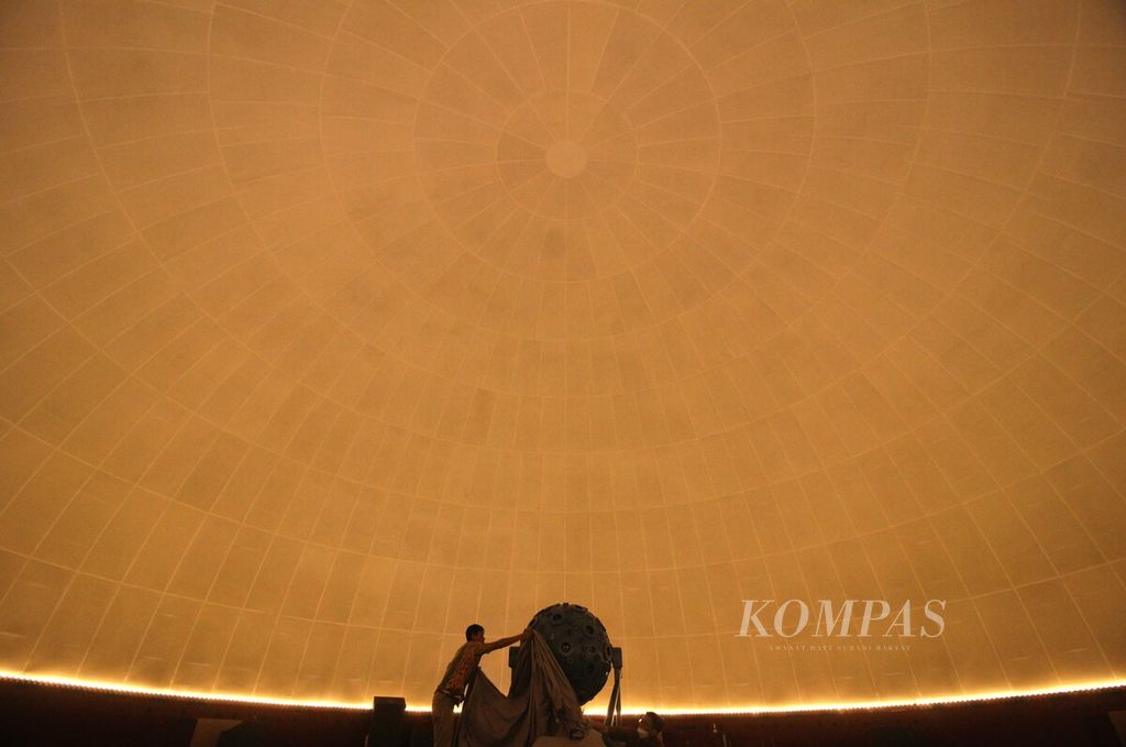 Petugas menutup <i>star ball </i>dengan kain di Teater Bintang di Planetarium dan Observatorium Jakarta, Taman Ismail Marzuki, Sabtu (5/11/2022). <i>Star ball </i>berfungsi memproyeksikan gambaran bintang dan planet dalam sistem alam semesta.