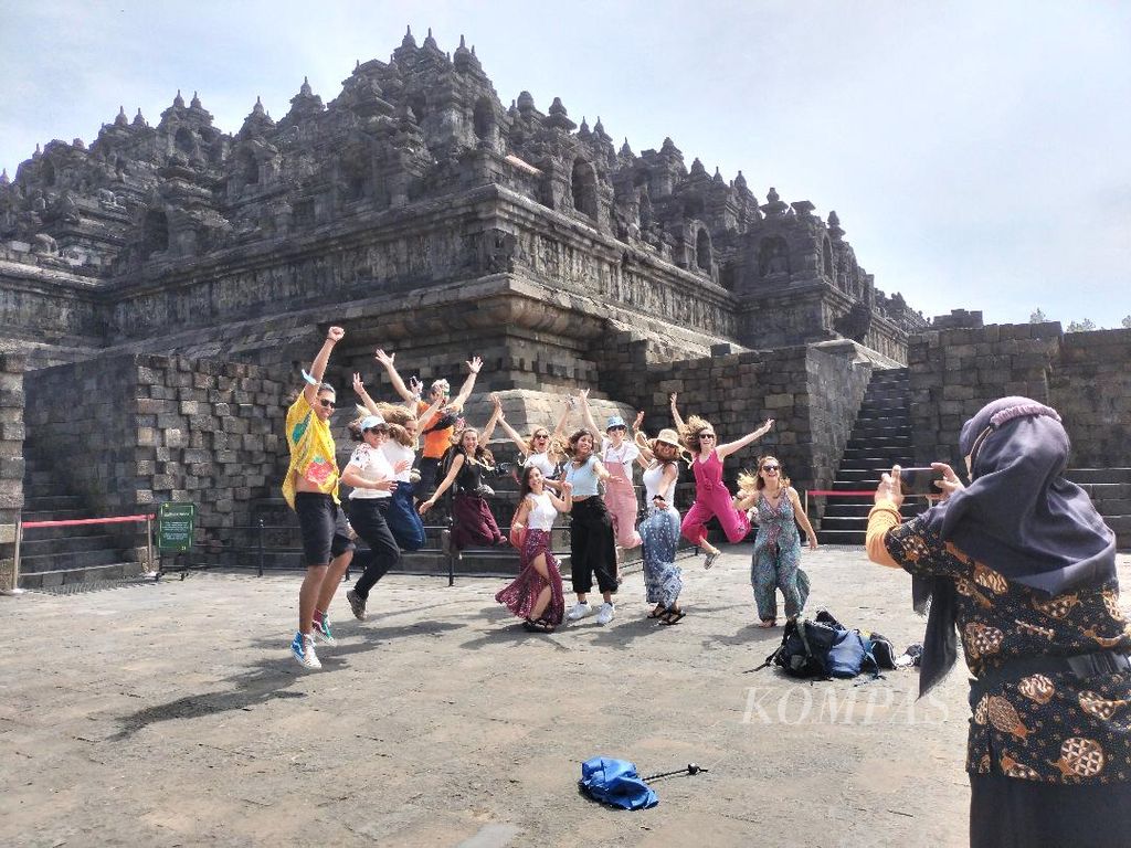 Rombongan wisatawan asal Spanyol berpose dan berfoto di depan Candi Borobudur, Senin (4/7/2022). Pengambilan foto dilakukan oleh pemandu wisata yang mendampingi mereka.