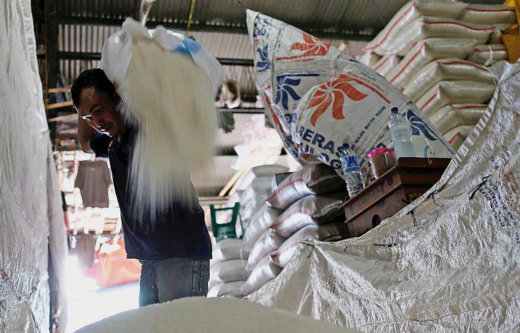 Buruh membongkar beras di Pasar Induk Beras Cipinang, Jakarta, Minggu (9/7). Untuk menjaga stabilitas harga beras, pemerintah akan terus membenahi tata niaga beras. Salah satunya caranya adalah dengan pendataan pelaku usaha, gudang, dan stok beras.