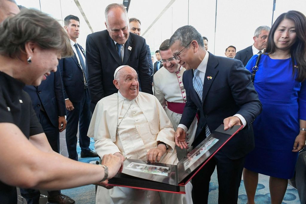 Paus Fransiskus diperlihatkan foto-foto dalam upacara perpisahan di Bandar Udara Internasional Changi di Singapura, Jumat (23/9/2024), sebelum terbang kembali ke Vatikan melalui Roma, Italia. 