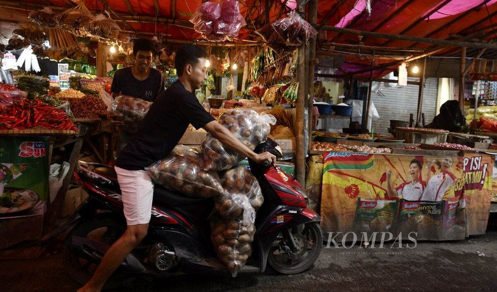Pekerja mengangkut kantong berisi kentang menggunakan sepeda motor di Pasar Anyar, Kota Tangerang, Banten, Selasa (29/3/2022).