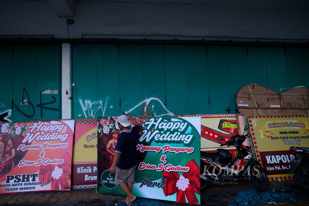 Pekerja menata bunga papan pesanan dari sejumlah pejabat dan instansi untuk pesta pernikahan Kaesang Pangarep dan Erina Gudono di Jalan Slamet Riyadi, Kota Surakarta, Jawa Tengah, Jumat (9/12/2022). 