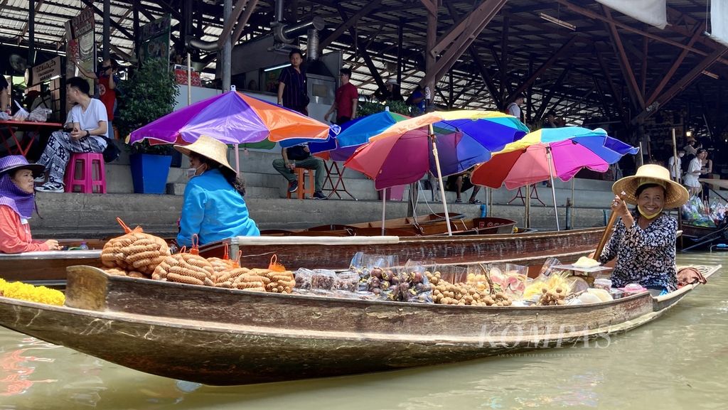 Seorang pengunjung menaiki perahu menuju Pasar Terapung Damnoen Saduak di Provinsi Ratchaburi, Thailand, pada Senin (27/3/2023). Pasar ini muncul setelah Raja Rama IV memerintahkan pembuatan kanal yang menghubungkan Sungai Mae Klong dengan Sungai Tha Chin sekitar 160 tahun lalu. 