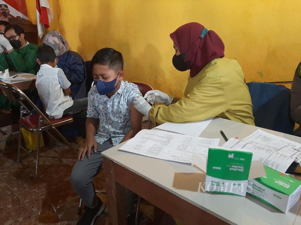Serang siswa SD mendapatkan suntikan vaksinasi dosis pertama di Balai Desa Banyusidi, Kecamatan Pakis, Kabupaten Magelang, Jawa Tengah, Selasa (11/1/2022).