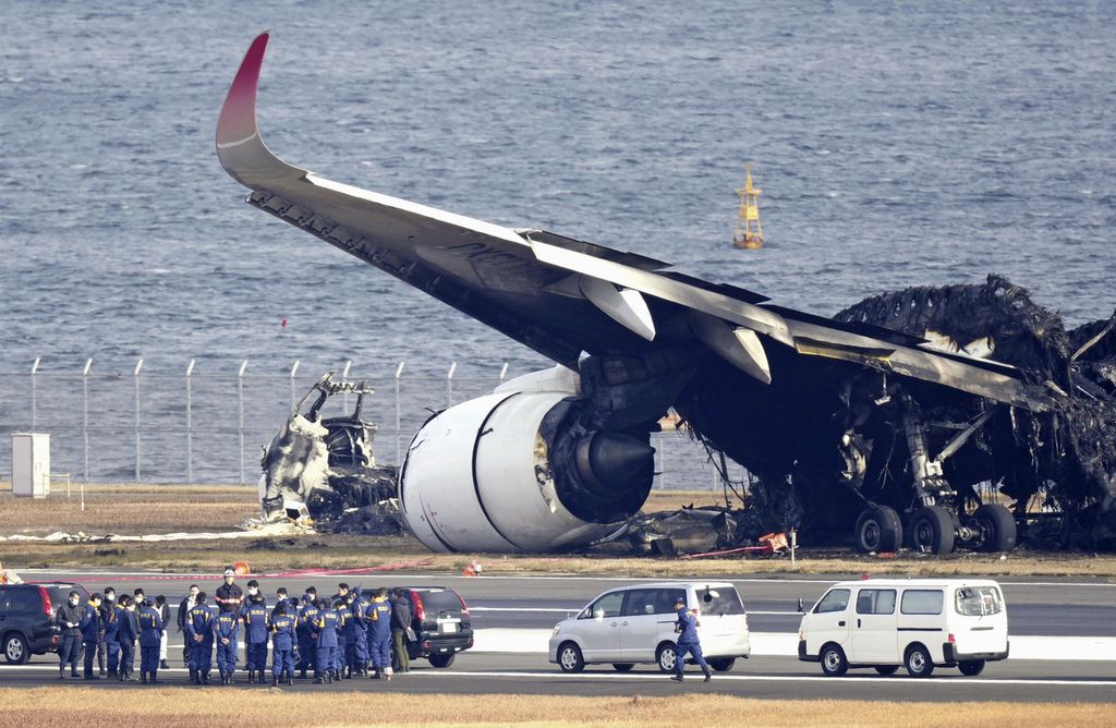 Penyelidik memeriksa puing pesawat Japan Airlines di  Bandara Haneda, Jepang, pada Kamis (4/1/2024). Pesawat terbakar setelah bertabrakan dengan pesawat Penjaga Pantai Jepang pada selasa lalu.